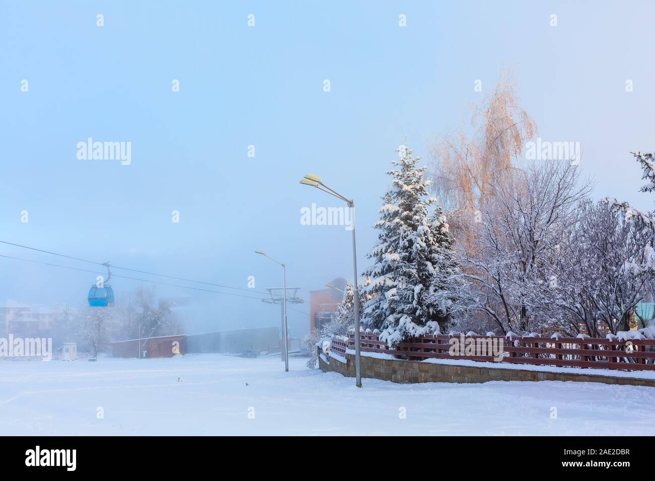 Bansko, Bulgarie hiver neige brouillard panorama avec piste de ski, télécabine cabines, clôture en bois Banque D'Images