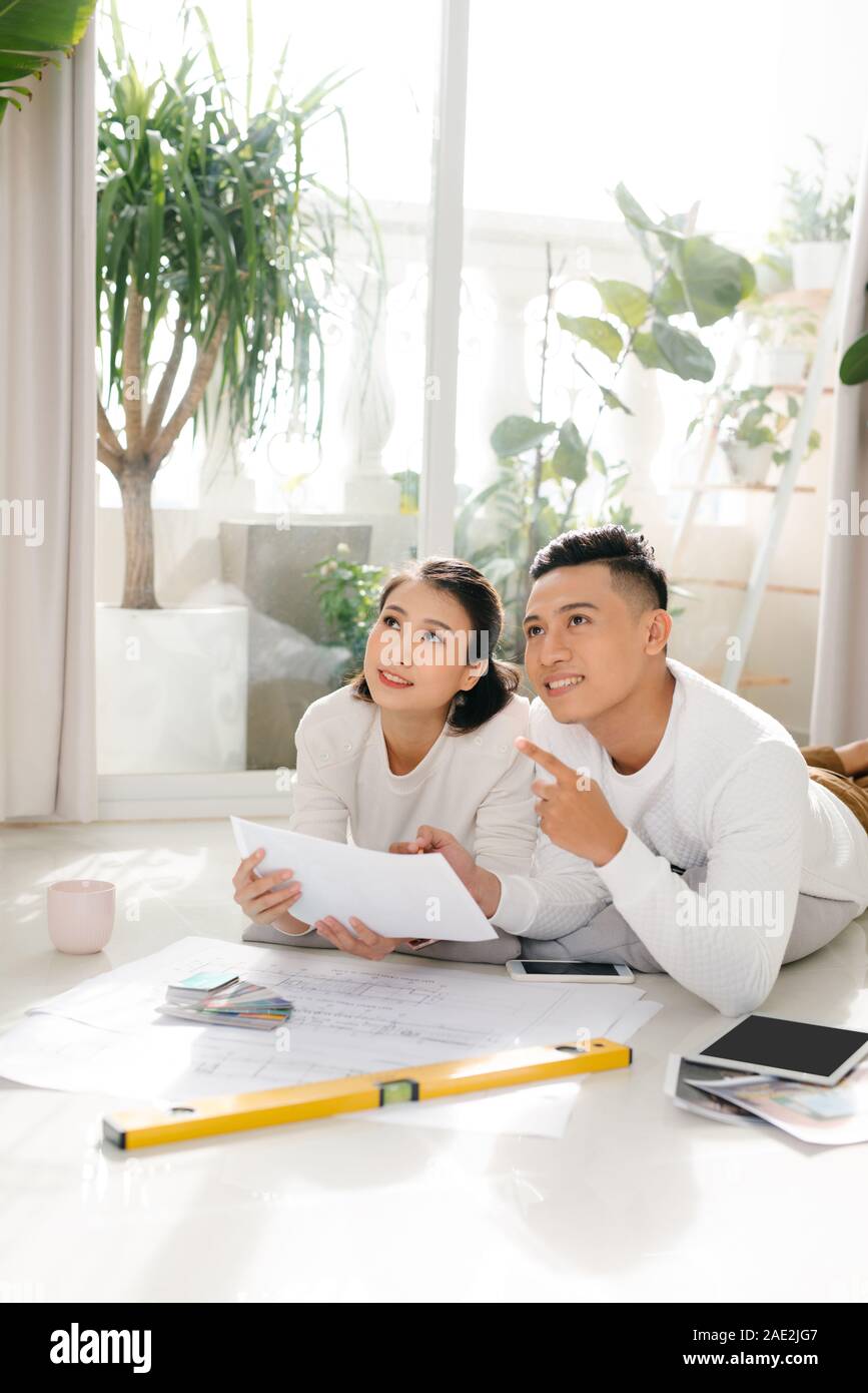 Cheerful couple looking at construction plan de maison Banque D'Images