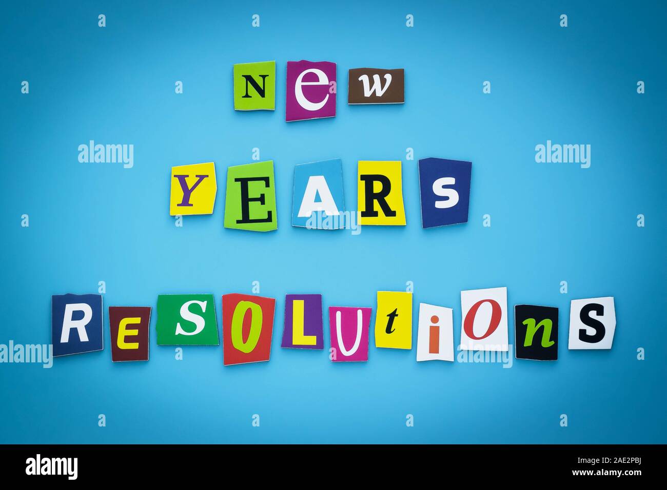 Texte - Résolutions du Nouvel an. Cut lettres colorées sur fond bleu. L'écriture sur la bannière, carte. L'inscription, un message sur l'affiche. Banque D'Images