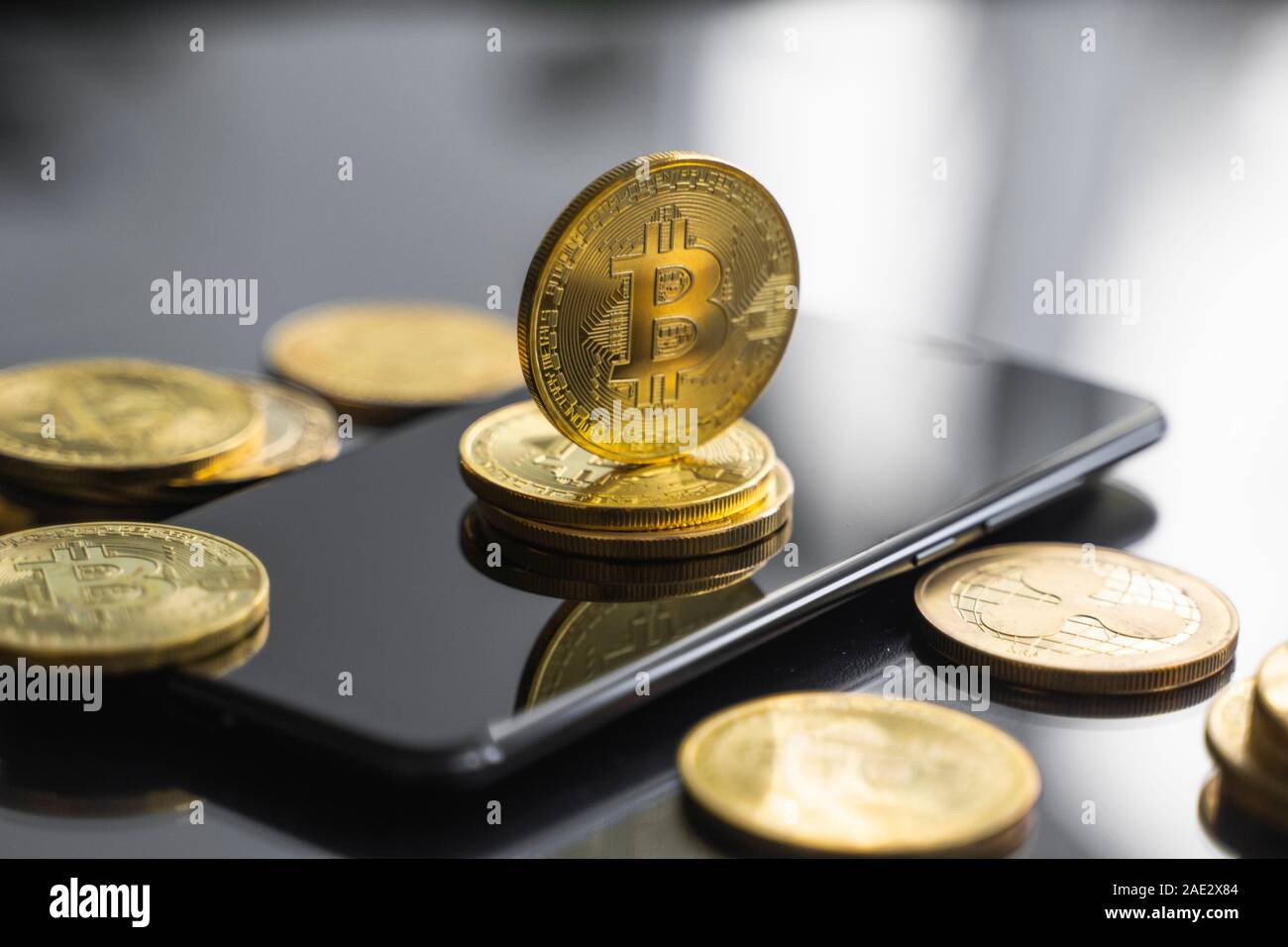 Bitcoin or coin sur un smartphone avec un grand nombre de pièces de bitcoins sur une table. Concept cryptocurrency virtuel. L'exploitation minière de bitcoins bussiness en ligne Banque D'Images