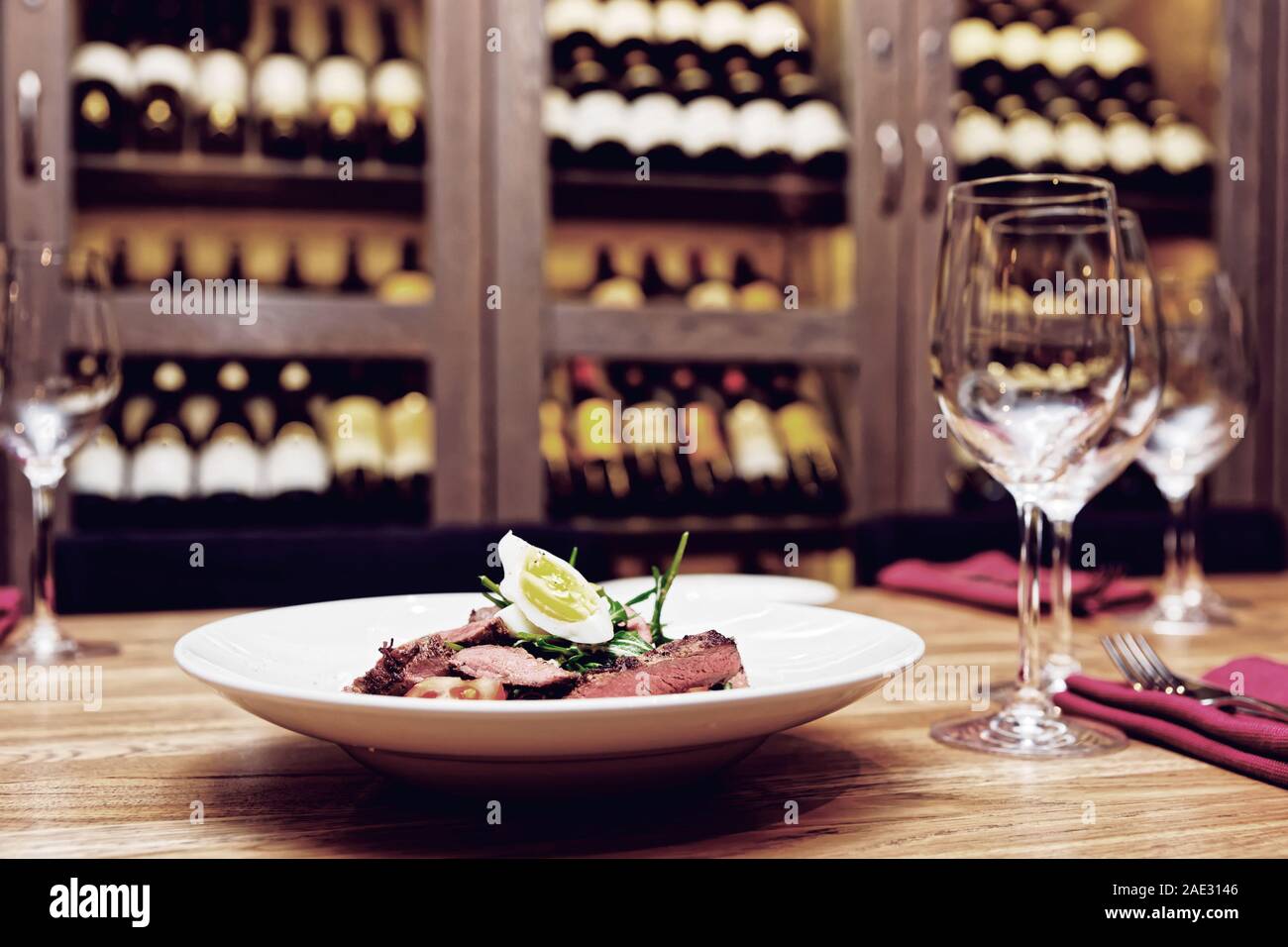 Rôti de boeuf apéritif sur table, vin en arrière-plan flou, photo Banque D'Images