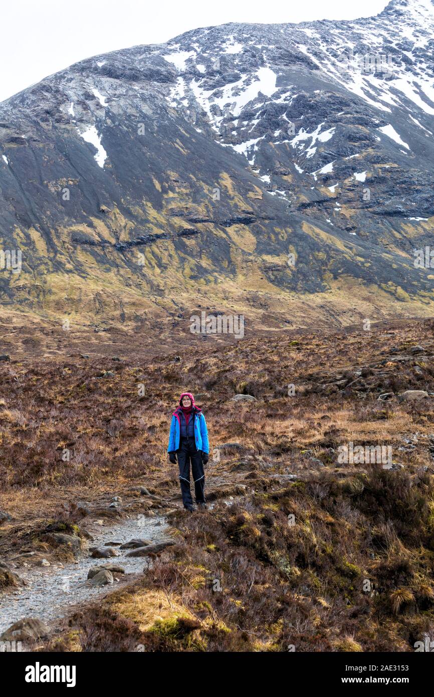 Femme marche à Black Cuillin et piscines de fées, rivière cassante, Isle of Skye, Scotland, UK en Mars Banque D'Images