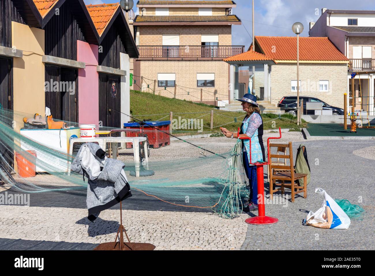 Vila Cha, au nord de Porto, Portugal. Une femme de pêcheur inspecte et réparer les filets de pêche monofilament gill2 Banque D'Images