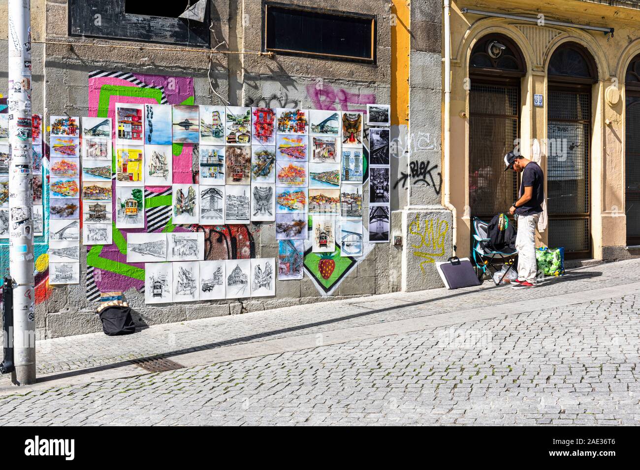 Artiste vend des affiches colorées et des reproductions de ses œuvres dépeignant des scènes typiques autour de Porto pour les touristes Banque D'Images