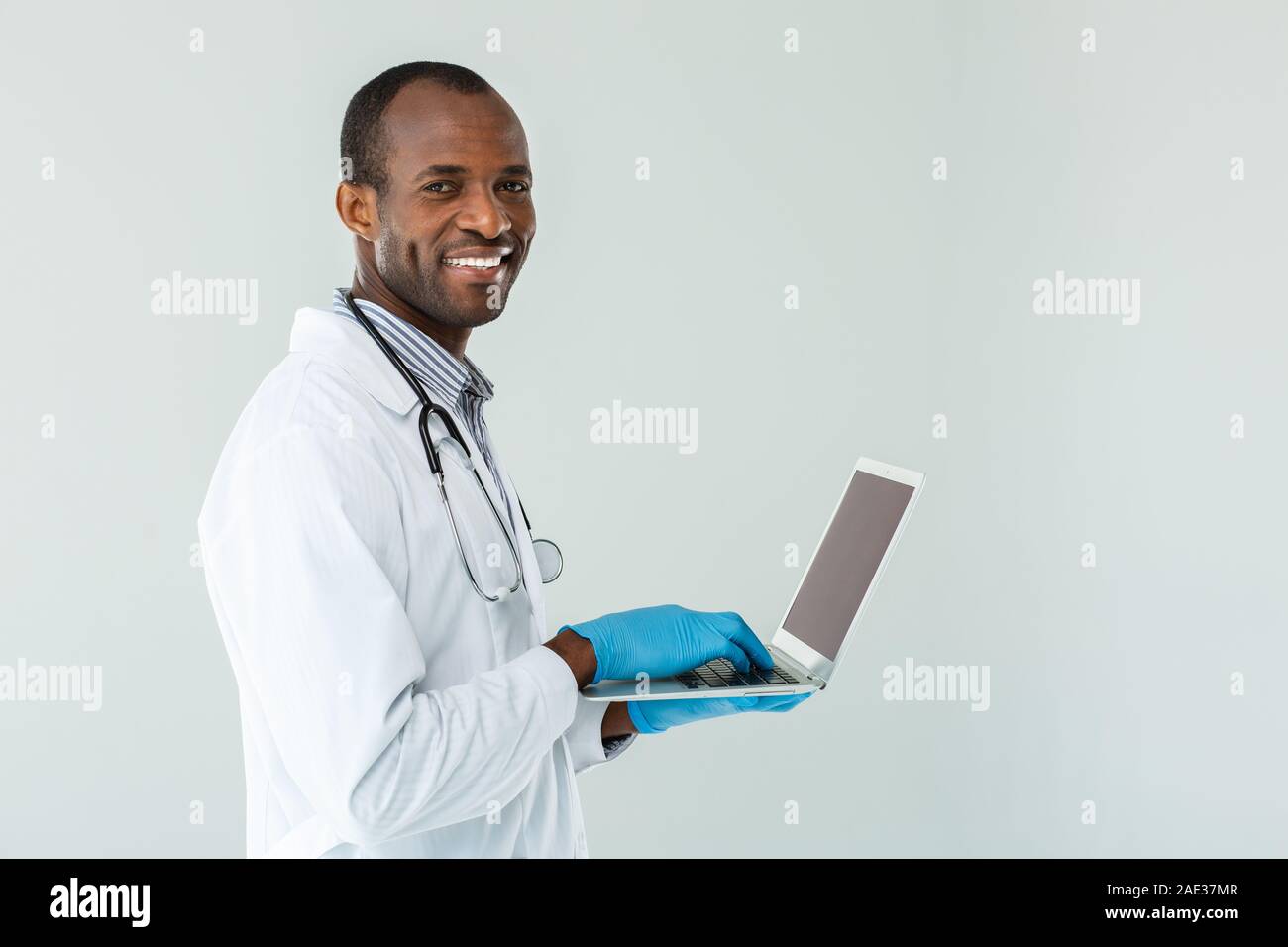 Médecin à l'aide de son ordinateur portable positive Banque D'Images