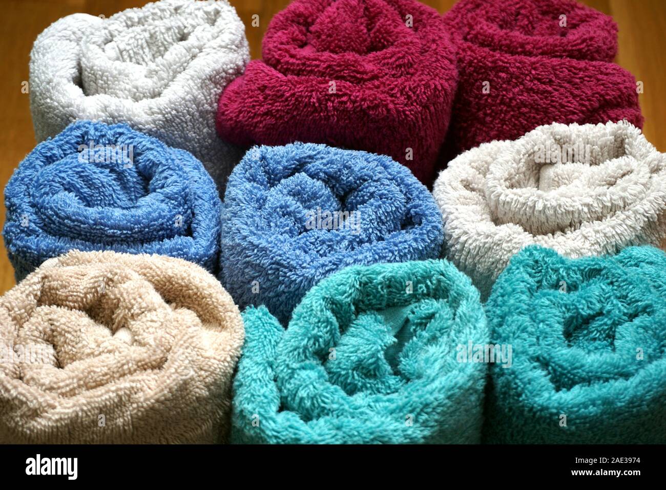 Les serviettes douces chaudes et colorées en coton naturel enroulé. Bain et soins du corps accessoires Banque D'Images