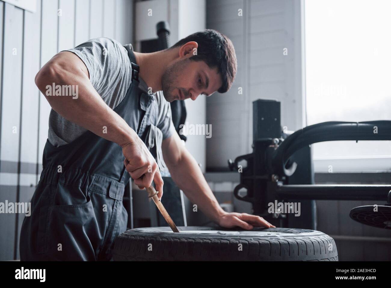 Il sait ce qu'il ne. Jeune homme travaille avec des disques du volant à l'atelier dans la journée Banque D'Images