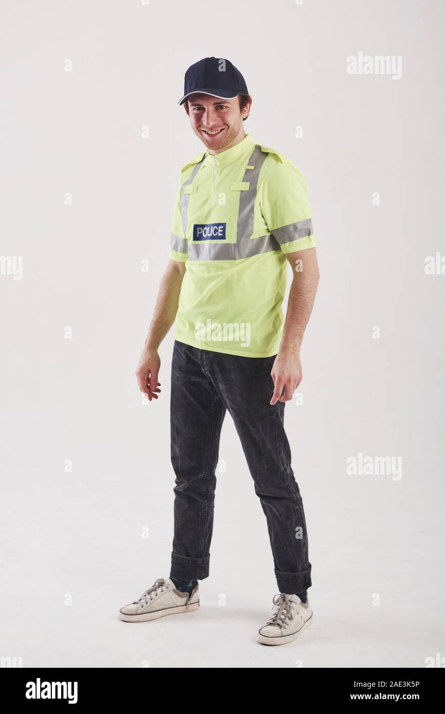 Pour votre sécurité. Policier en uniforme vert se dresse contre fond blanc dans le studio Banque D'Images