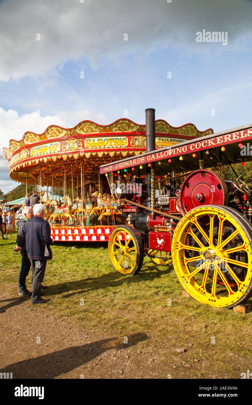 Vintage carousal à vapeur avec dadas étant entraînée par un moteur de traction à vapeur d'époque au Malpas Cheshire rallye d'antan Banque D'Images
