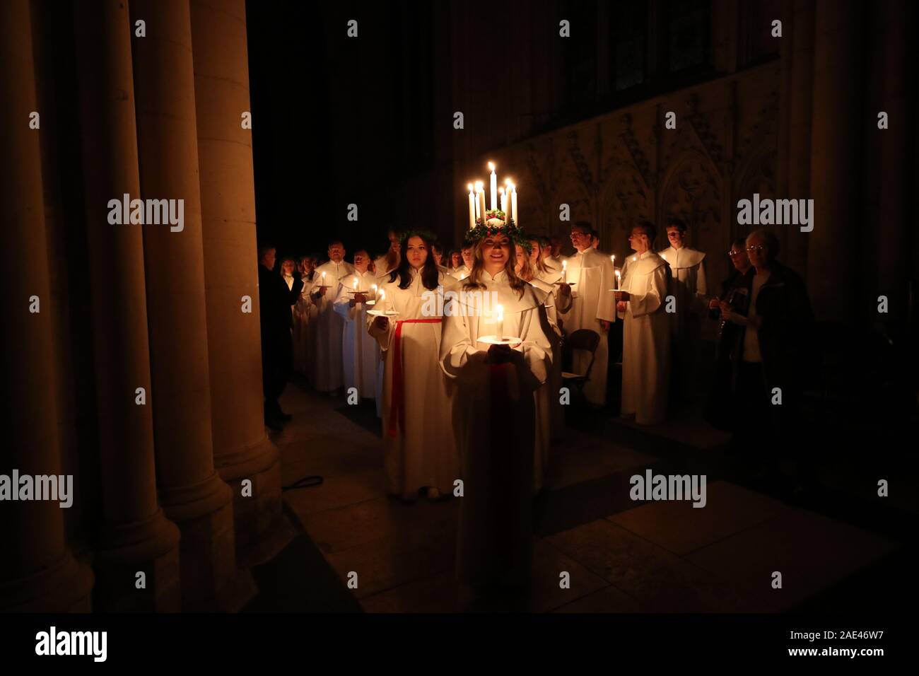 Matilda Bergstrom portant une couronne de bougies symbolisant St Lucy, conduit une procession aux chandelles du choeur nordique au cours de la London Sankta Lucia service à York Minster. Photo date : vendredi 6 décembre 2019. Le service suédois de l'atmosphère est une célébration de Sainte Lucie, une fille sicilien martyrisé pour sa foi chrétienne au quatrième siècle. La couronne symbolise un halo, une écharpe rouge son martyre, et le service célèbre l'occasion de l'entrée de la lumière au cours de l'obscurité de l'hiver. Crédit photo doit se lire : Danny Lawson/PA Wire Banque D'Images