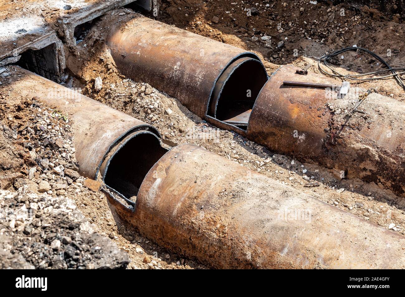 Les travaux de construction sur les tuyaux en fer à une profondeur de tranchée excavée Banque D'Images