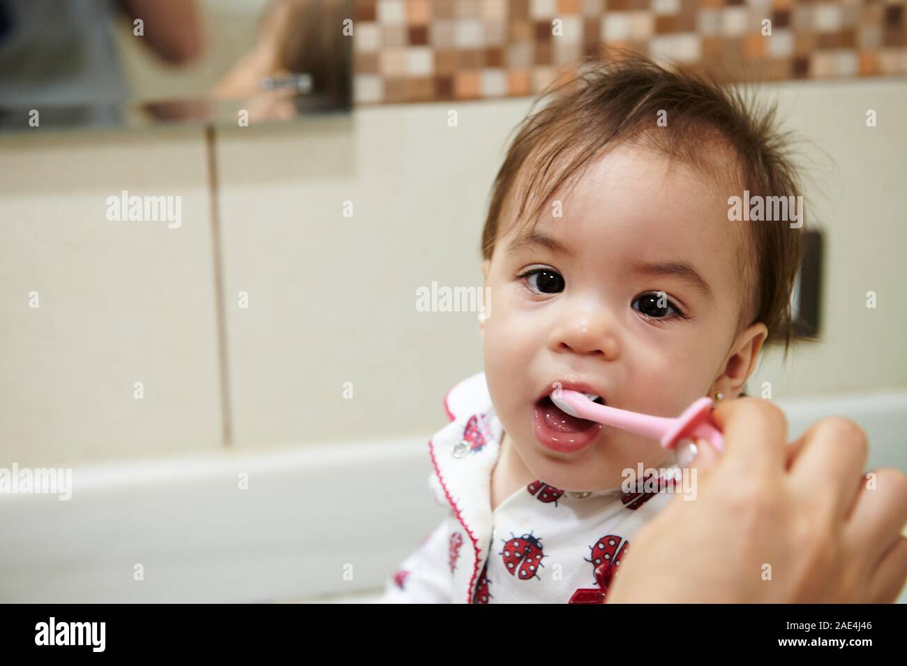 Le brossage des dents pour enfants thème. Portrait of baby girl avec une brosse à dents dans la bouche Banque D'Images