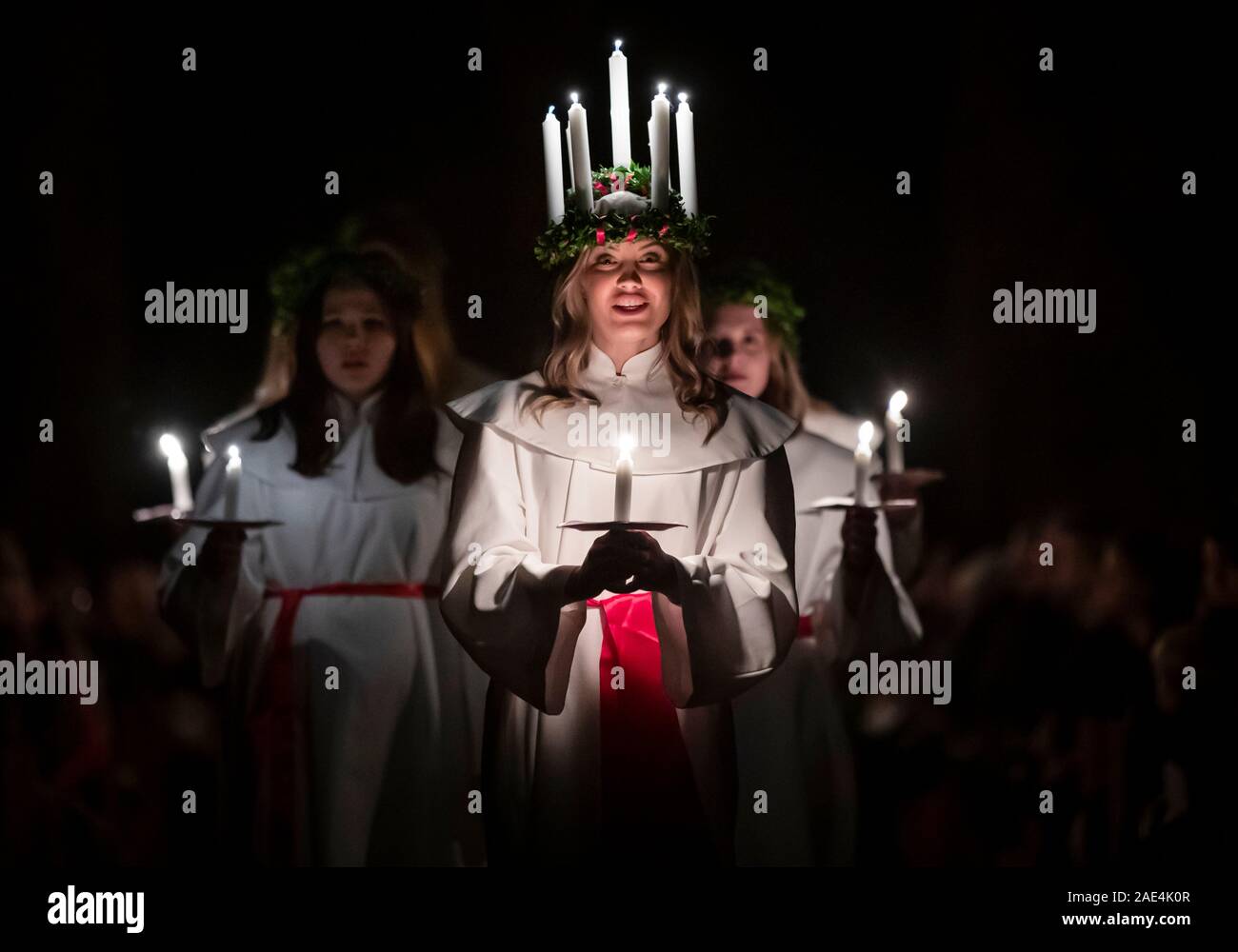 Matilda Bergstrom portant une couronne de bougies symbolisant St Lucy, conduit une procession aux chandelles du choeur nordique au cours de la London Sankta Lucia service à York Minster. Photo date : vendredi 6 décembre 2019. Le service suédois de l'atmosphère est une célébration de Sainte Lucie, une fille sicilien martyrisé pour sa foi chrétienne au quatrième siècle. La couronne symbolise un halo, une écharpe rouge son martyre, et le service célèbre l'occasion de l'entrée de la lumière au cours de l'obscurité de l'hiver. Crédit photo doit se lire : Danny Lawson/PA Wire Banque D'Images