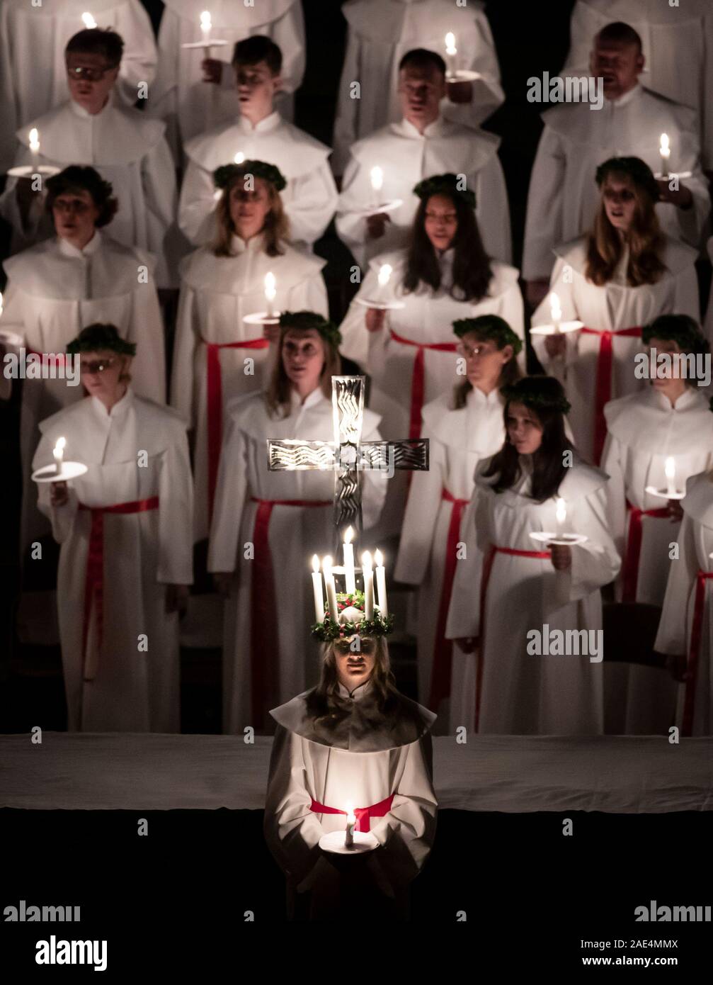 Matilda Bergstrom portant une couronne de bougies symbolisant St Lucy, conduit une procession aux chandelles du choeur nordique au cours de la London Sankta Lucia service à York Minster. Photo date : vendredi 6 décembre 2019. Le service suédois de l'atmosphère est une célébration de Sainte Lucie, une fille sicilien martyrisé pour sa foi chrétienne au quatrième siècle. La couronne symbolise un halo, une écharpe rouge son martyre, et le service célèbre l'occasion de l'entrée de la lumière au cours de l'obscurité de l'hiver. Crédit photo doit se lire : Danny Lawson/PA Wire Banque D'Images