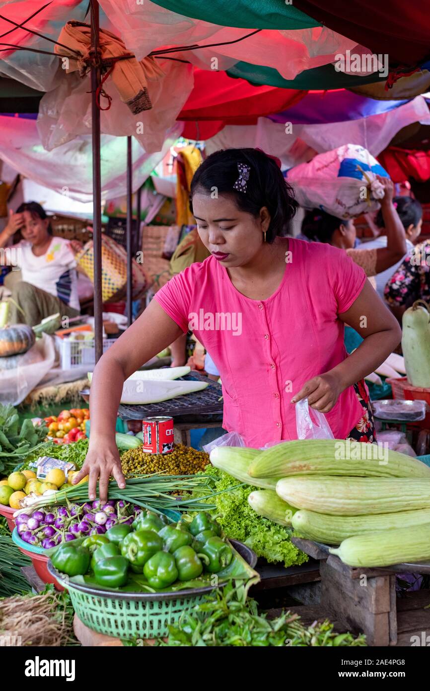 Une femme birmane dans un chemisier rose vente de fruits et légumes frais dans le marché ferroviaire de Mandalay, Myanmar (Birmanie) Banque D'Images