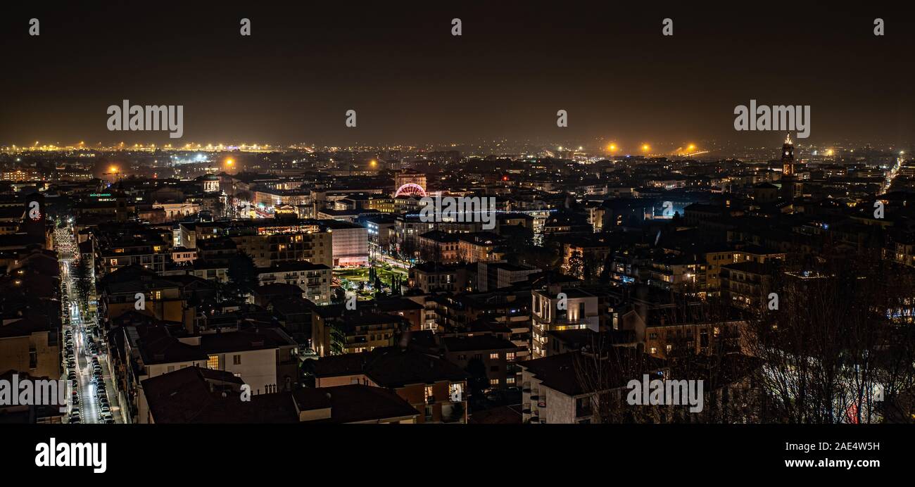 Vue de nuit vu de Bergame Città Alta, lumières sur la ville et les détails de la grande roue installée pour la période de Noël. Banque D'Images