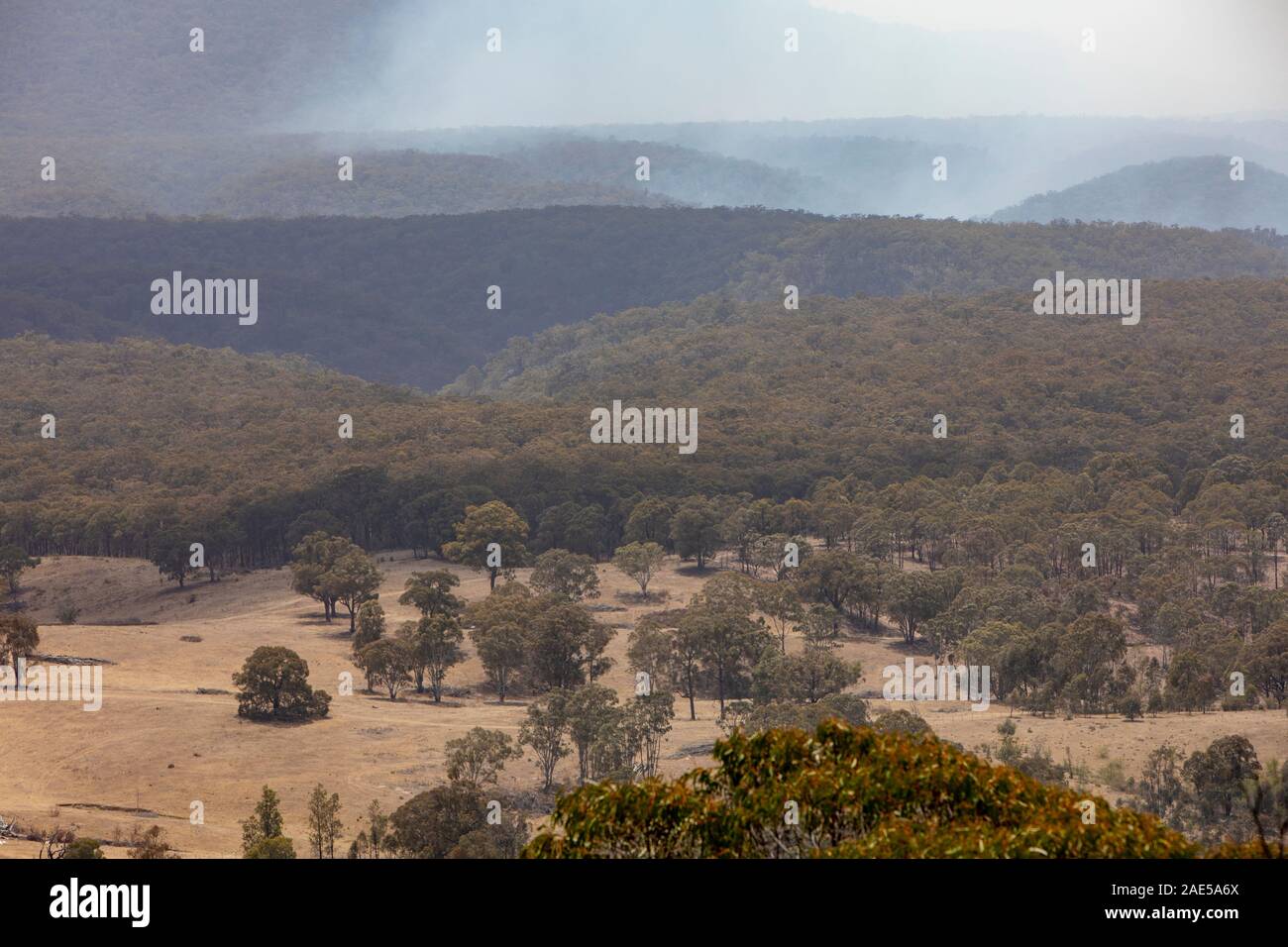 La fumée provenant des feux de brousse dans la brume Capertee Valley National Park, New South Wales, Australie Banque D'Images