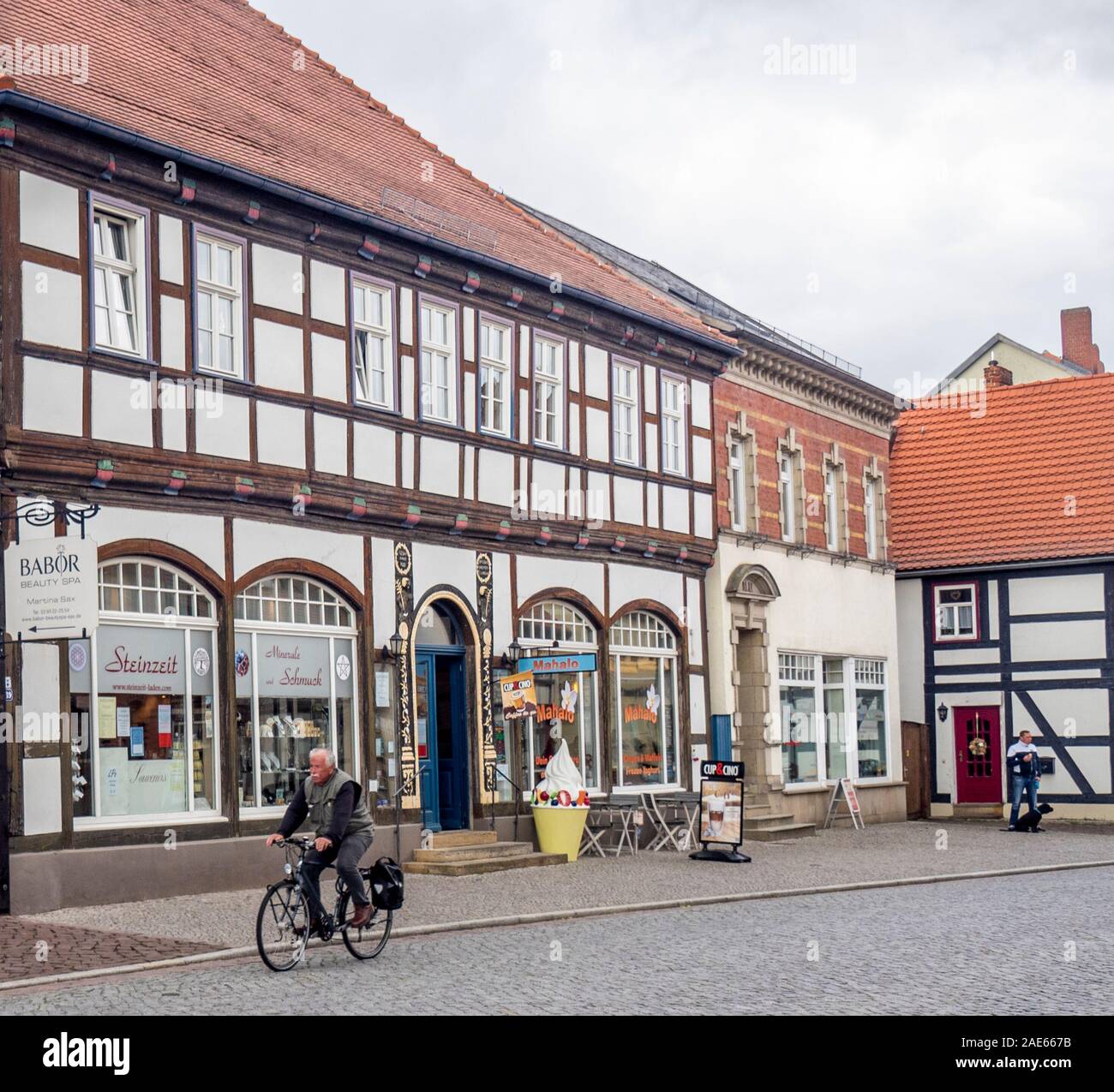 Homme âgé vélo devant les bâtiments à ossature de bois dans l'historique Altstadt Tangermünde Saxe-Anhalt Allemagne. Banque D'Images