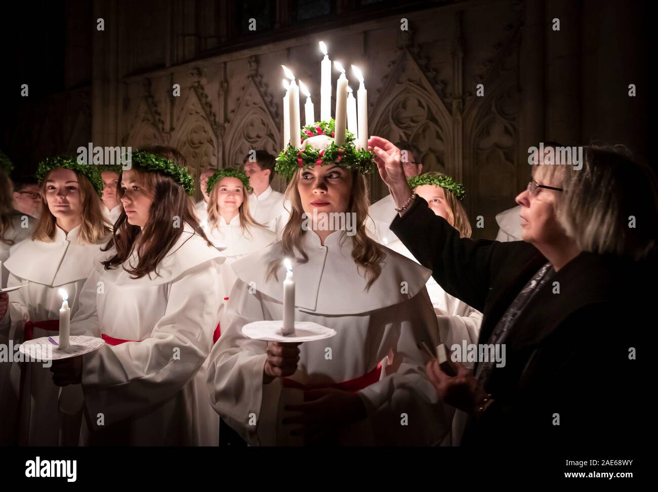 Matilda Bergstrom portant une couronne de bougies symbolisant St Lucy, conduit une procession aux chandelles du choeur nordique au cours de la London Sankta Lucia service à York Minster. Photo date : vendredi 6 décembre 2019. Le service suédois de l'atmosphère est une célébration de Sainte Lucie, une fille sicilien martyrisé pour sa foi chrétienne au quatrième siècle. La couronne symbolise un halo, une écharpe rouge son martyre, et le service célèbre l'occasion de l'entrée de la lumière au cours de l'obscurité de l'hiver. Histoire voir l'ACTIVITÉ DE LA RELIGION publique. Crédit photo doit se lire : Danny Lawson/PA Wire Banque D'Images