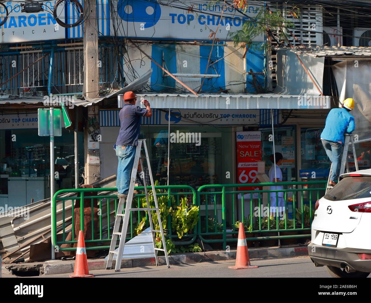 Bangkok, Thaïlande - le 4 décembre 2019 : un travailleur debout sur l'échelle à l'aide de perceuse pour faire le trou pour l'installation d'un nouveau toit en aluminium Banque D'Images