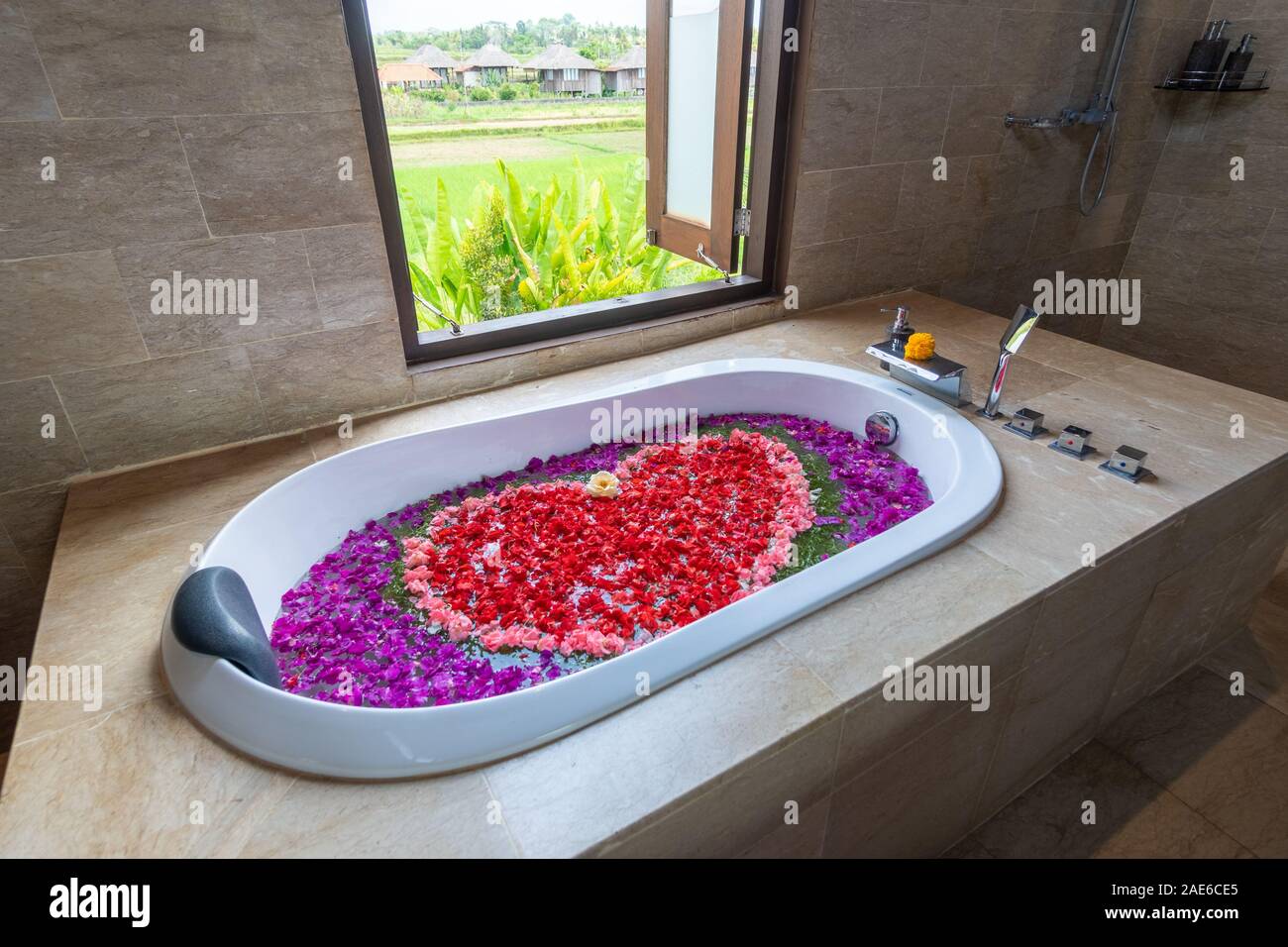 Baignoire remplie de diverses fleurs en forme de coeur avec fenêtre ouverte  donnant sur les rizières Photo Stock - Alamy