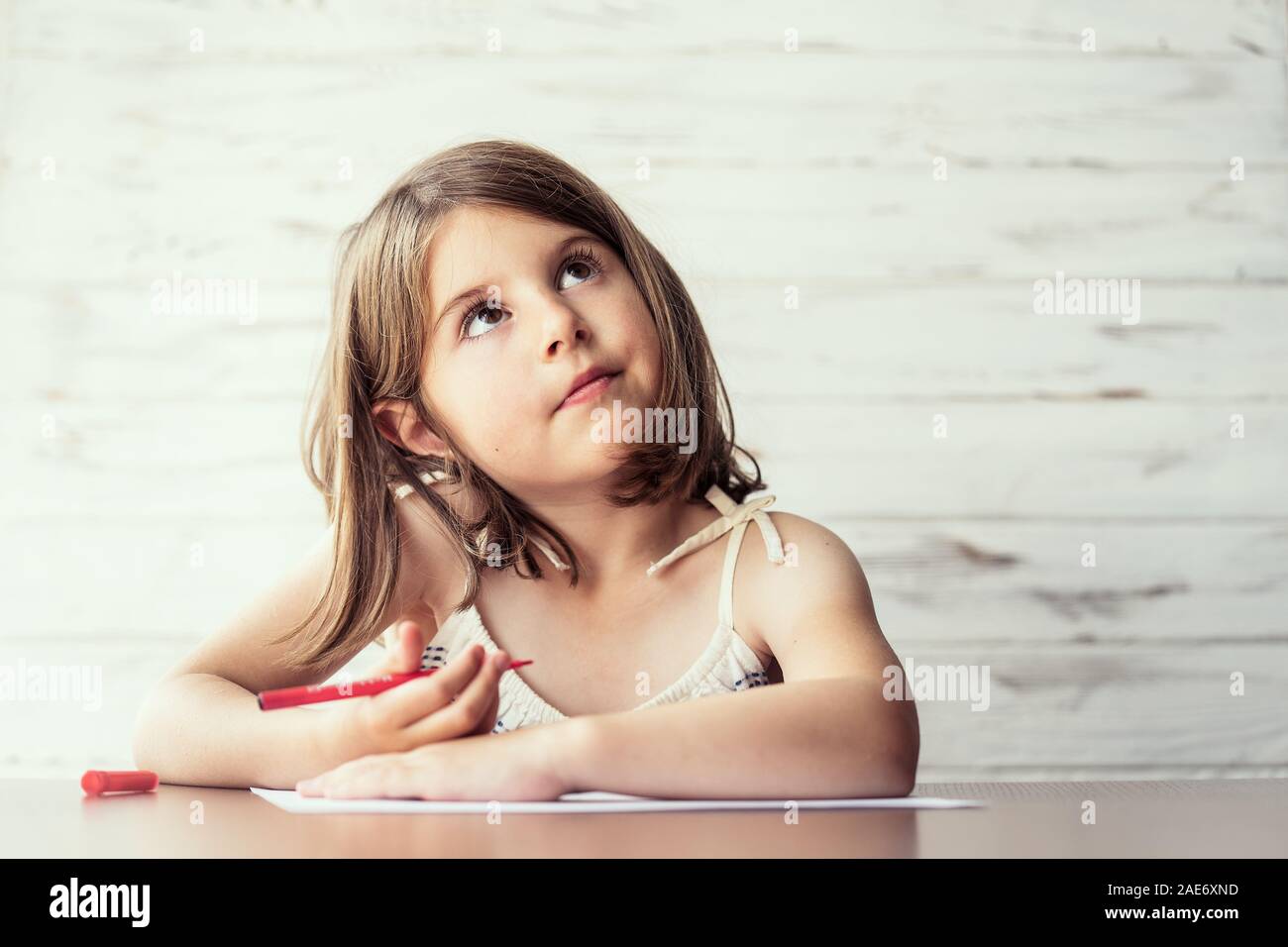 Portrait de belle petite fille réfléchie avec un crayon dans la main la  rêverie et la création photo idées dans son esprit. Processus de création.  L'éducation et Photo Stock - Alamy