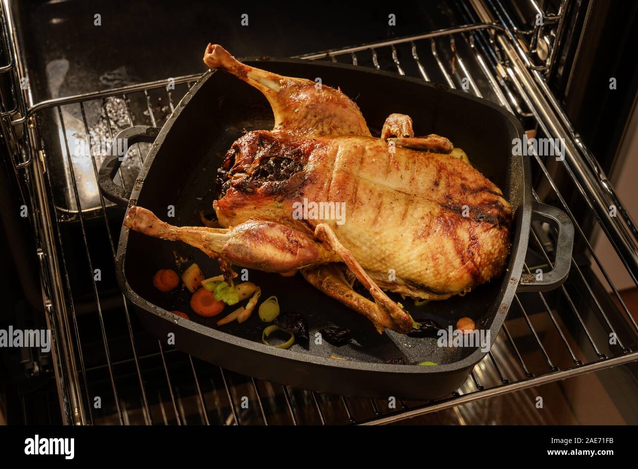 Canard entier rôti dans une casserole noire sur une grille dans le four pour un menu de fête, Noël mise au point sélectionné Banque D'Images