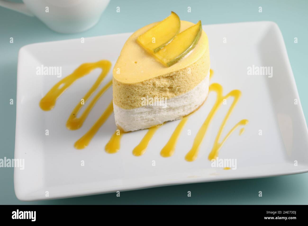 La mangue et de la crème dessert garni de tranches de mangue sur une assiette décorée avec de la purée de mangue Banque D'Images