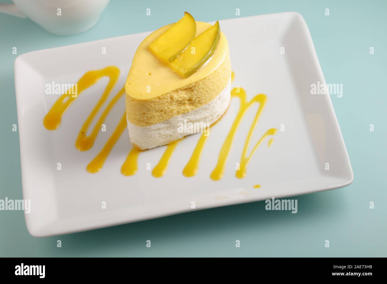 La mangue et de la crème dessert garni de tranches de mangue sur une assiette décorée avec de la purée de mangue Banque D'Images