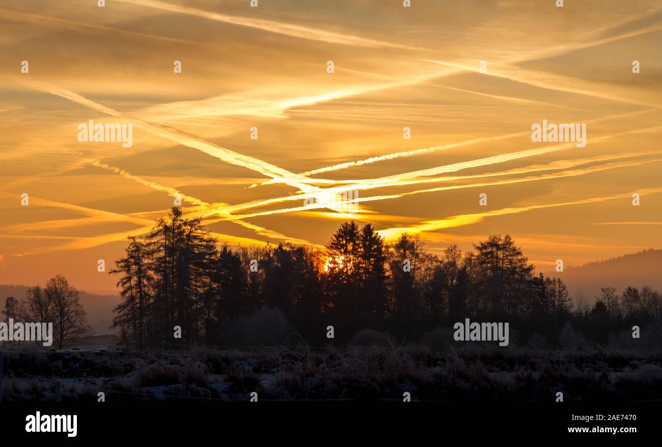 Lever du soleil romantique sur un froid matin d'hiver avec jet trails, région Waldviertel, Autriche Banque D'Images