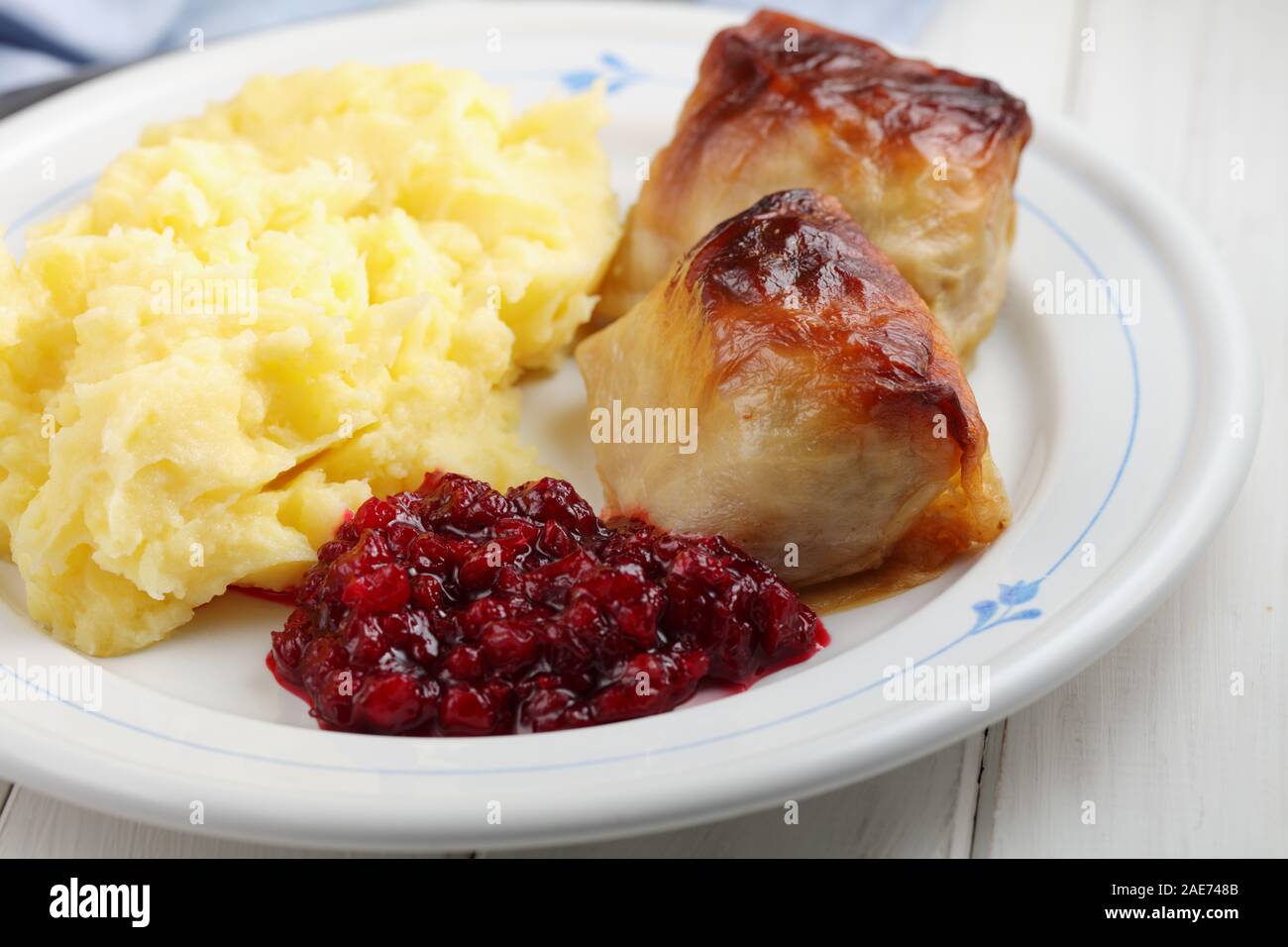 Deux choux finlandais Kaalikaaryleet avec une purée de pommes de terre et de confiture d'airelles sur une table rustique Banque D'Images