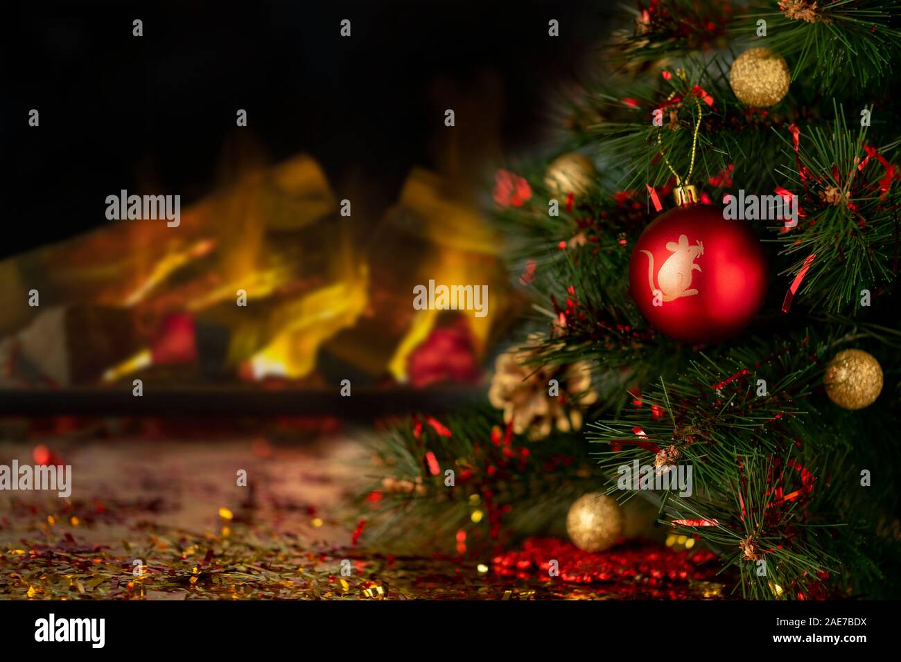 Boule de Noël rouge avec symbole de nouvelle année sur un sapin. Cheminée dans bluried arrière-plan. Vacances de Noël arrière-plan avec copie espace. Abstract Banque D'Images Boule de Noël rouge avec symbole de nouvelle année sur un sapin. Cheminée dans bluried arrière-plan. Vacances de Noël arrière-plan avec copie espace. Abstract Banque D'Images