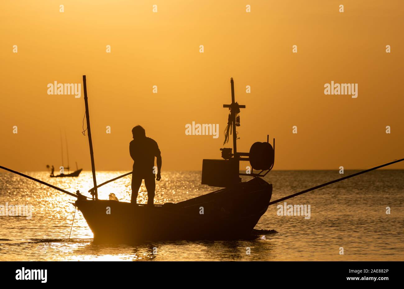 Silhouette de voile et de pêcheur avec de l'éclairage faible et le coucher du soleil ombre sombre. Banque D'Images