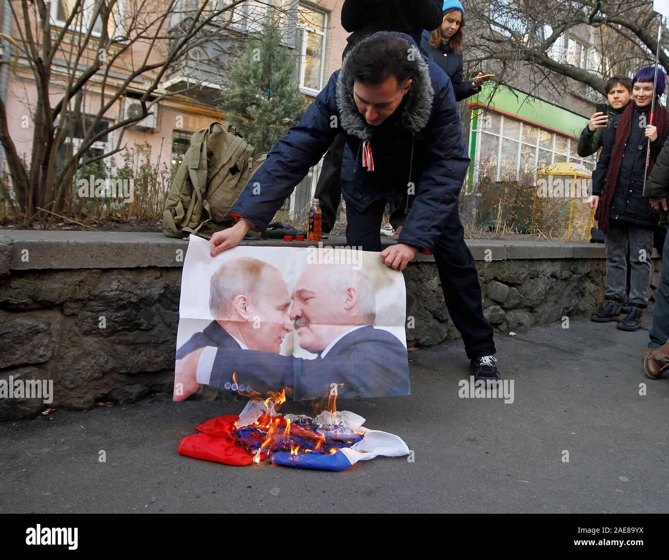 Les manifestants ukrainiens et biélorusses brûler le drapeau de la Russie au cours d'une manifestation contre le Bielorussie-russie programme d'intégration en Kiev.manifestants s'opposent à l'intégration de la Biélorussie et de la Russie et d'examiner ce signe un nouvel accord de l'approfondissement de l'intégration peut conduire à perdre le Bélarus son indépendance. Présidents de la Russie et le Bélarus, Vladimir Poutine et Alexandre Loukachenko rencontrer et parler de feuilles de route pour l'intégration des deux pays en cours en Russie le 7 décembre 2019, apparemment par des médias. Banque D'Images