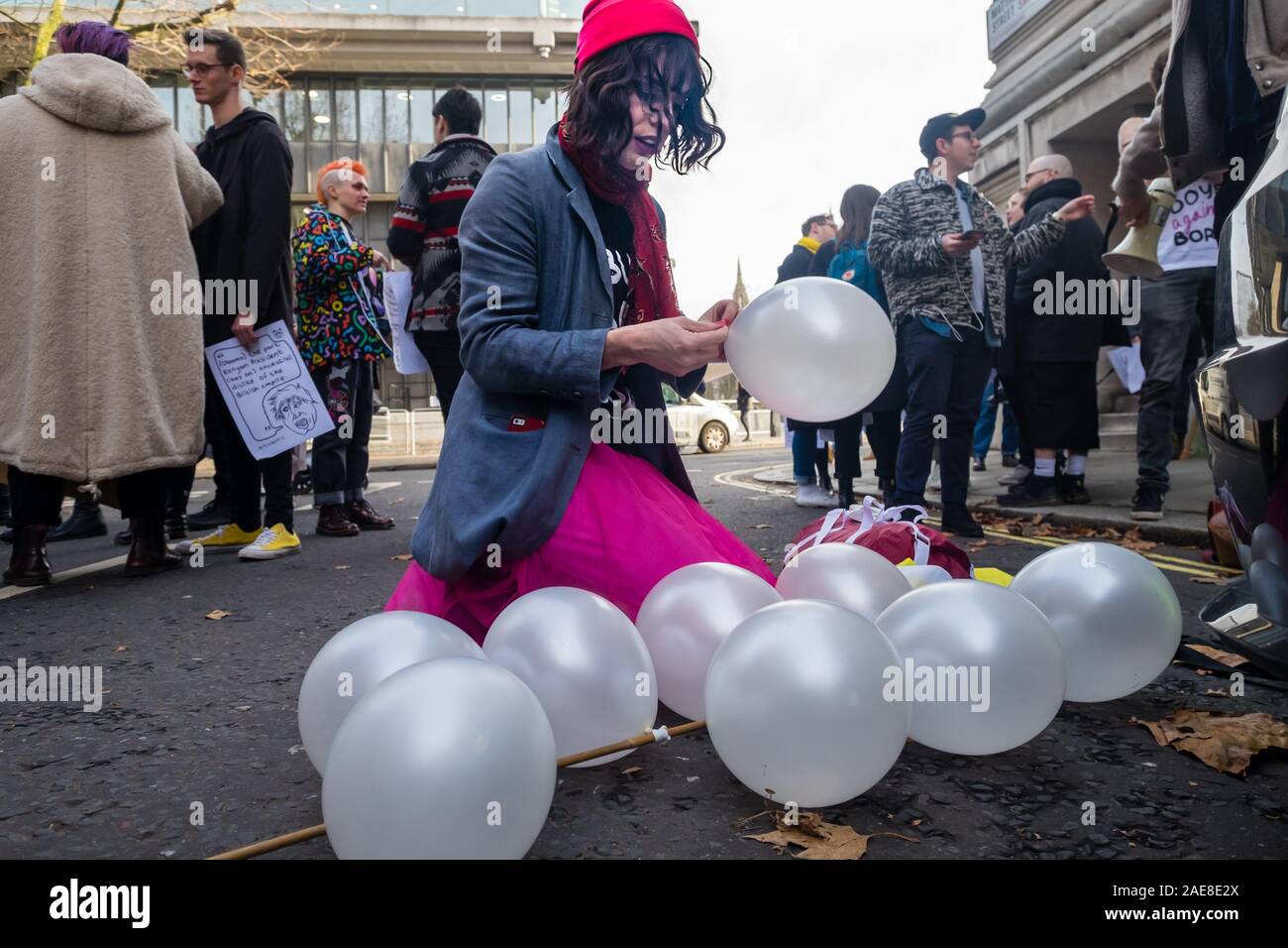 Londres, Royaume-Uni. 7 décembre 2019. Un militant coups des ballons à mars une arcade. Boris Johnson a déclaré : "Si le mariage gay était OK puis j'ai vu aucune raison de principe pour laquelle un syndicat ne devrait pas être consacré entre trois hommes et un chien." les militants LGBT + qui ont repris l'étiquette de Boris 'bum boys' organiser un mariage pour 3 hommes et un chien à l'extérieur de l'administration centrale de la campagne des Conservateurs pour protester contre cette et ses autres homophobe, raciste, sexiste et ableist commentaires avant de marcher à un rassemblement à l'extérieur de Downing St Peter Marshall/Alamy Live News Banque D'Images