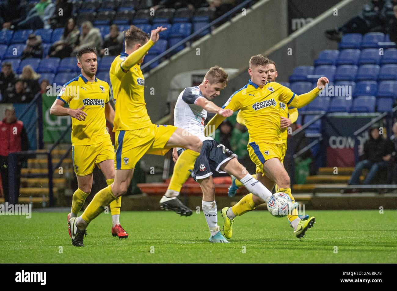 Stade de Bolton, Bolton, Royaume-Uni. 7 Décembre, 2019. Bolton Wanderers' Ronan Darcy tente un tir au but par la défense de Wimbledon lors de la Sky Bet League 1 match entre Bolton Wanderers et l'AFC Wimbledon à l'Université de Bolton, Bolton Stadium le samedi 7 décembre 2019. (Crédit : Ian Charles | MI News) photographie peut uniquement être utilisé pour les journaux et/ou magazines fins éditoriales, licence requise pour l'usage commercial Crédit : MI News & Sport /Alamy Live News Banque D'Images