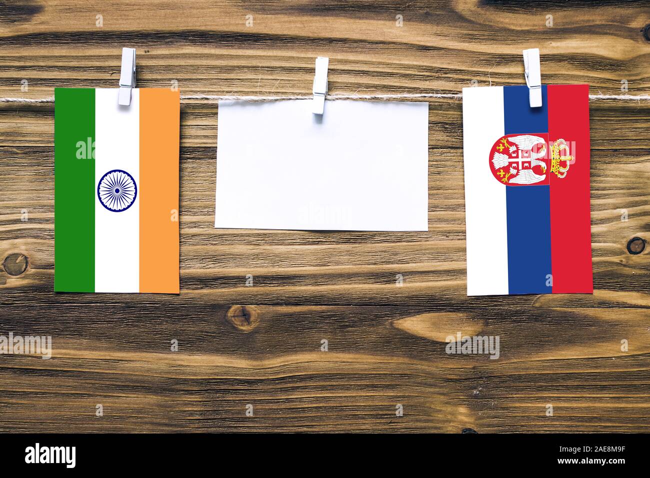 Drapeaux suspendus de l'Inde et la Serbie attaché à corde avec pinces à linge avec de l'espace de copie sur papier blanc sur fond de bois.Les relations diplomatiques bet Banque D'Images