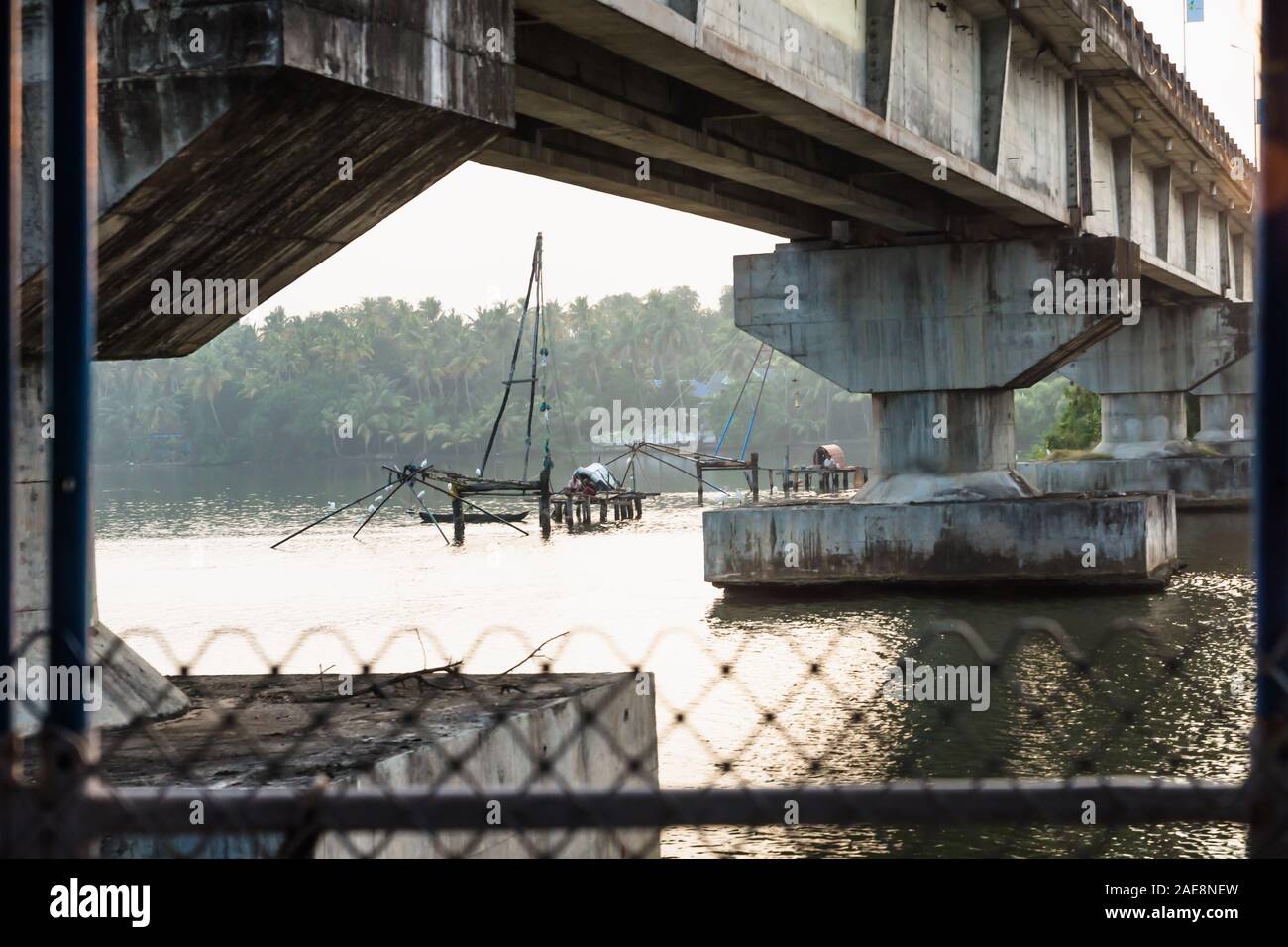 Filet de pêcheur chinois sous un pont le long de la voie navigable le long kottapuram kollam palm tree river shore, Kerala, Inde Banque D'Images