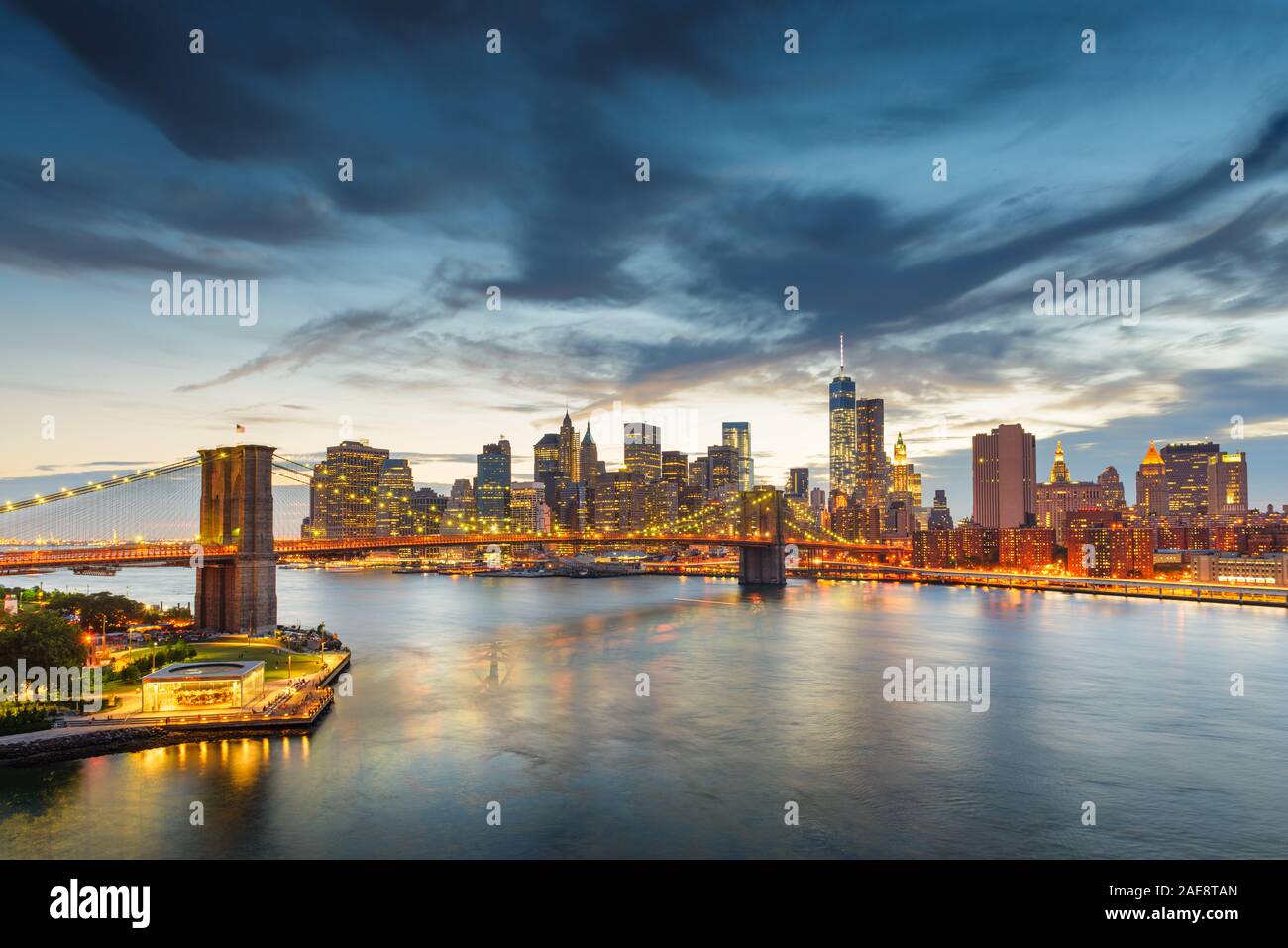 New York, New York, USA Le centre-ville de Manhattan skyline de la ville sur l'East River avec le Pont de Brooklyn au crépuscule. Banque D'Images