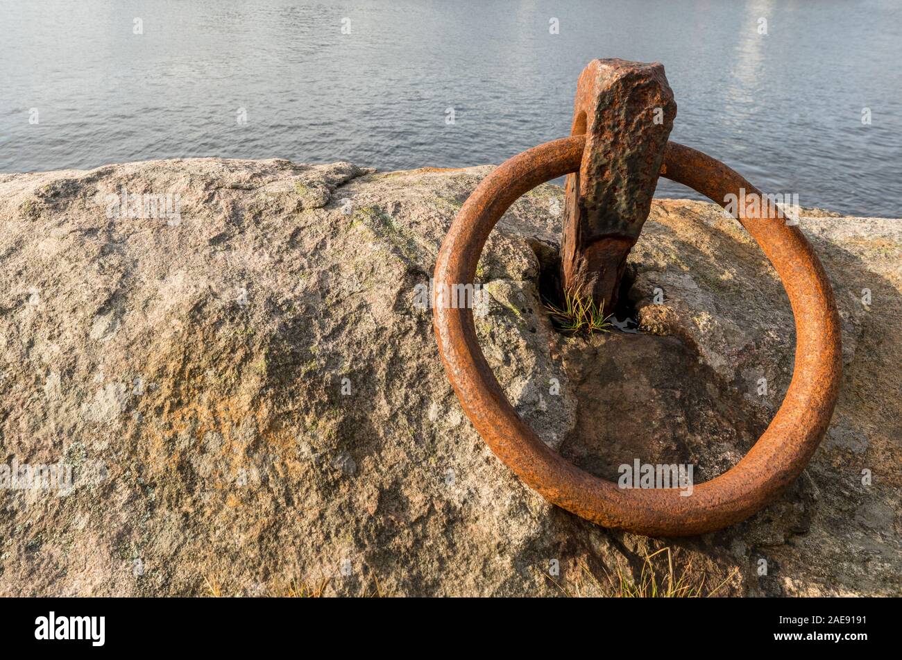 Anneau de rouille pour l'amarrage d'un bateau sur le rocher à l'océan Banque D'Images