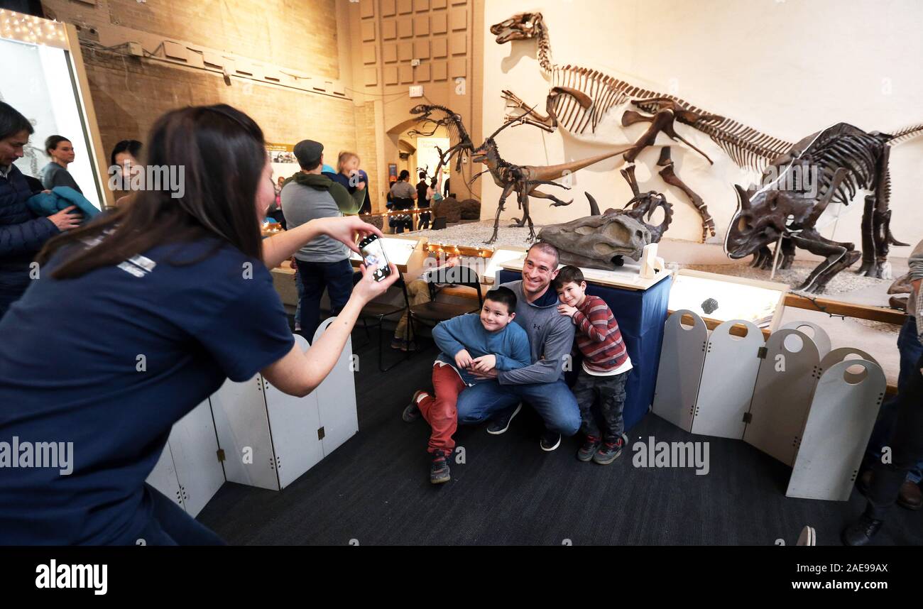 New Haven, CT, USA. 7 Décembre, 2019. 7 décembre 2019 - New Haven, Connecticut : VANESS RHUE, Responsable des Collections, prend des photos des visiteurs de musées posant avec le crâne du brontosaure à la Yale Peabody Museum dans la Grande Salle. Le musée abrite l'échantillon original de brontosaure, à laquelle Othniel Charles Marsh, professeur de paléontologie à l'Université Yale, a donné le nom Brontosaurus excelsus en 1879. C'est la première phase dans un musée-large pour permettre la fermeture de la plupart des travaux de rénovation dans le Peabody de l'histoire, et qui est financé par des dons. Le musée sera fermé le 30 juin Banque D'Images