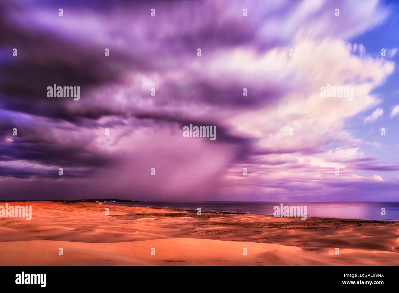 Stockton Beach dunes de sable sur la côte pacifique de l'Australie près de Anna bay ville locale au coucher du soleil. Scenic cloudscape floues dans une longue exposition au cours scenic w Banque D'Images