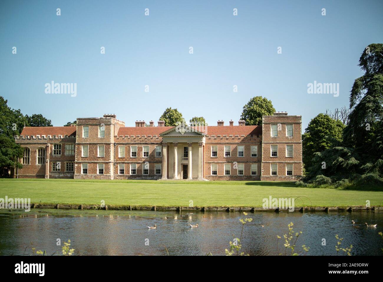 Face Nord de l'Vyne, construit 1500-1520, derrière le lac créé à partir de Shir Brook. Montrant les pelouses et portique classique ajouté en 1654 par John Webb. Banque D'Images