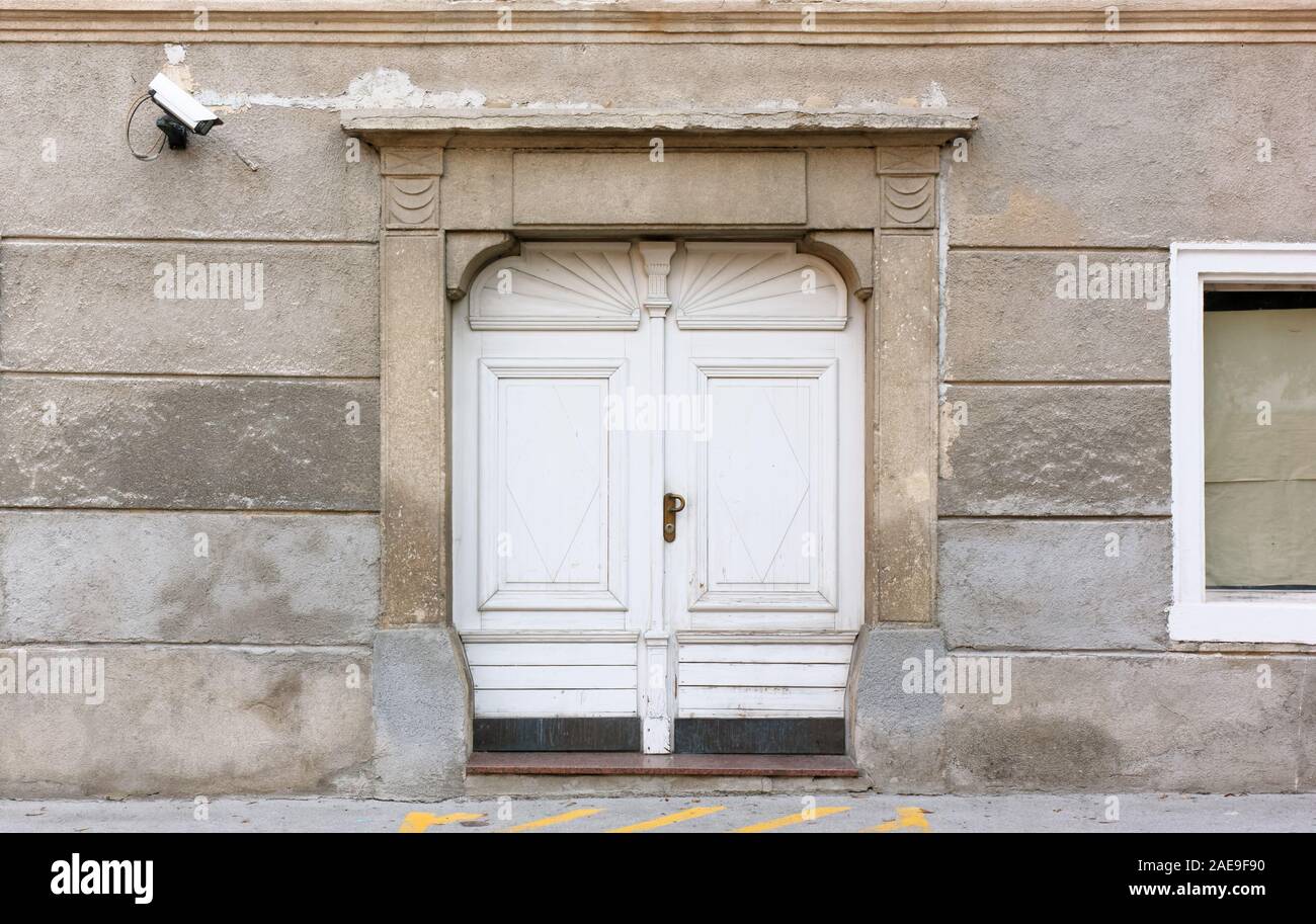 Entrée d'un bâtiment historique, avec une caméra de surveillance moderne sur le mur et un jaune no parking sign sur le sol Banque D'Images