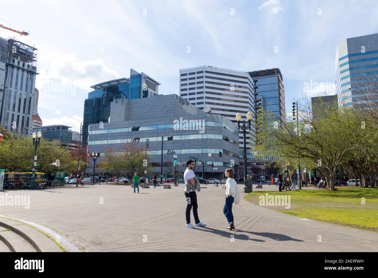 Portland, Oregon / USA - Circa 2019 : un jeune homme et une femme ayant une conversation au bord de l'eau fontaine en centre-ville de Portland, Oregon. Banque D'Images