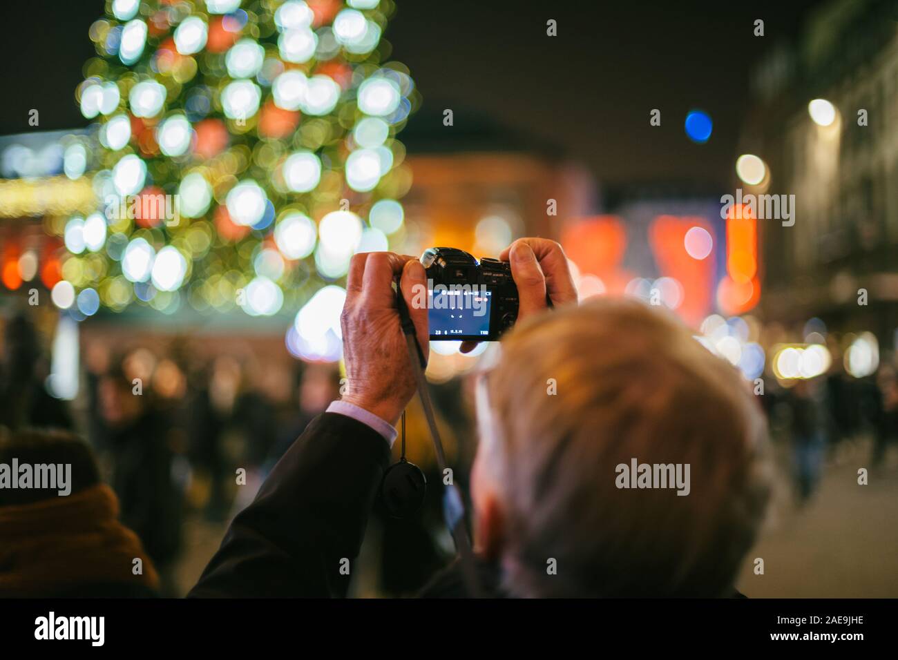 Strasbourg, France - Dec 20, 2016 : man photographie avec l'appareil photo mirrorless du grand sapin de Noël au centre de la Place Kléber lors des marches de Noel beau bokeh Banque D'Images