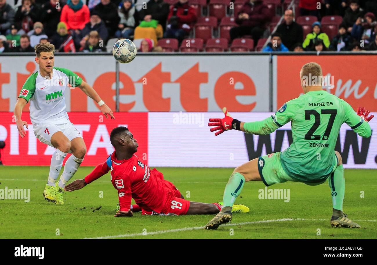 Augsburg, Allemagne. 7 Décembre, 2019. Florian Niederlechner (L) d'Augsbourg prend un coup dans la défense de Moussa Niakhate (C) de Mayence au cours d'un match de Bundesliga allemande entre FC Augsburg et 1.FSV Mayence 05 à Augsburg, Allemagne, le 7 décembre 2019. Crédit : Philippe Ruiz/Xinhua/Alamy Live News Banque D'Images