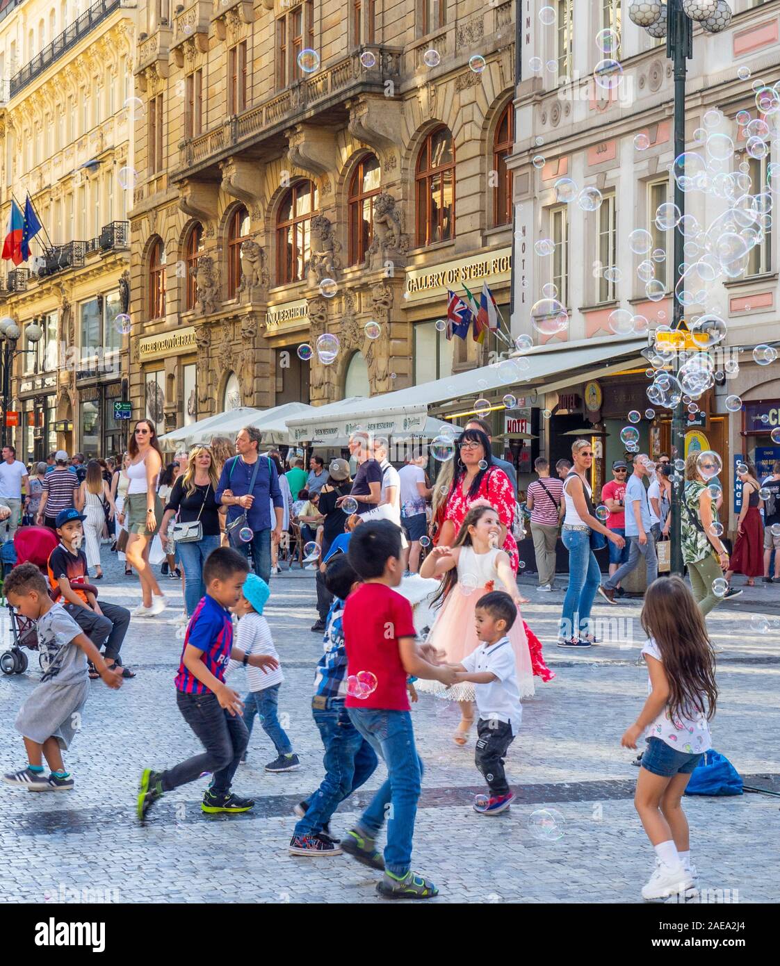 Les enfants qui tentent de capturer des bulles dans la vieille ville de Prague, République tchèque. Banque D'Images