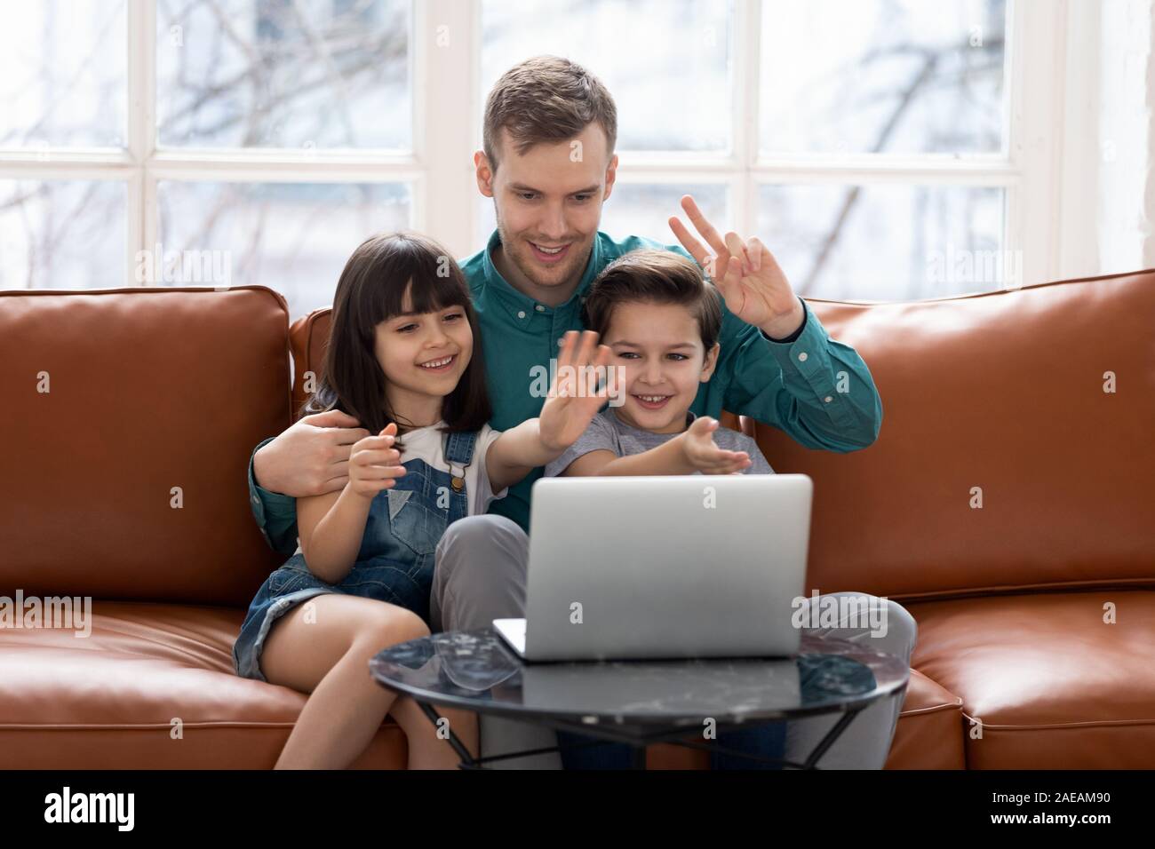 Père aimant avec petite fille et fils à l'aide d'appel vidéo. Banque D'Images