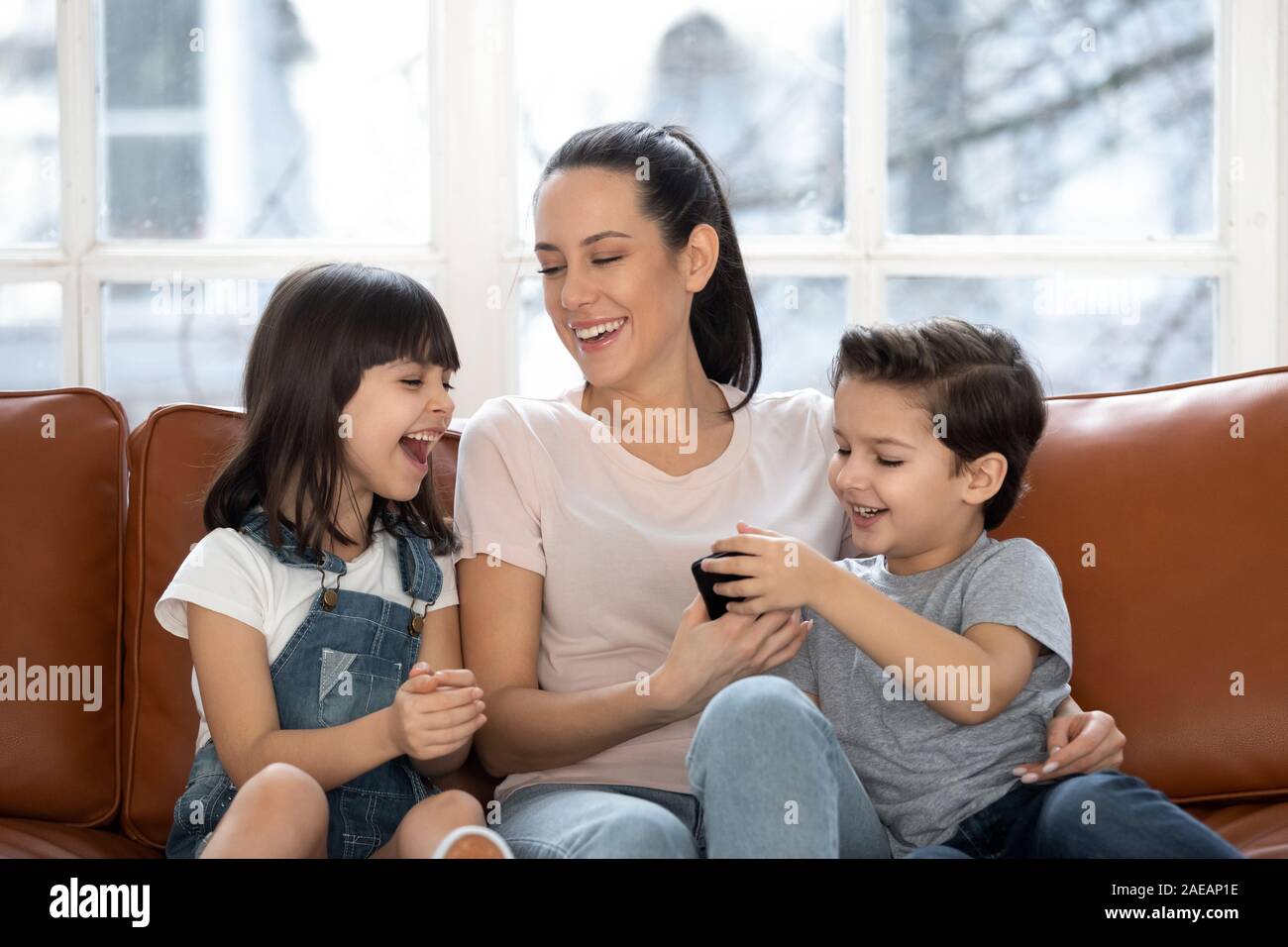 Heureuse fête avec rire mignon fille et fils à l'aide de votre smartphone. Banque D'Images